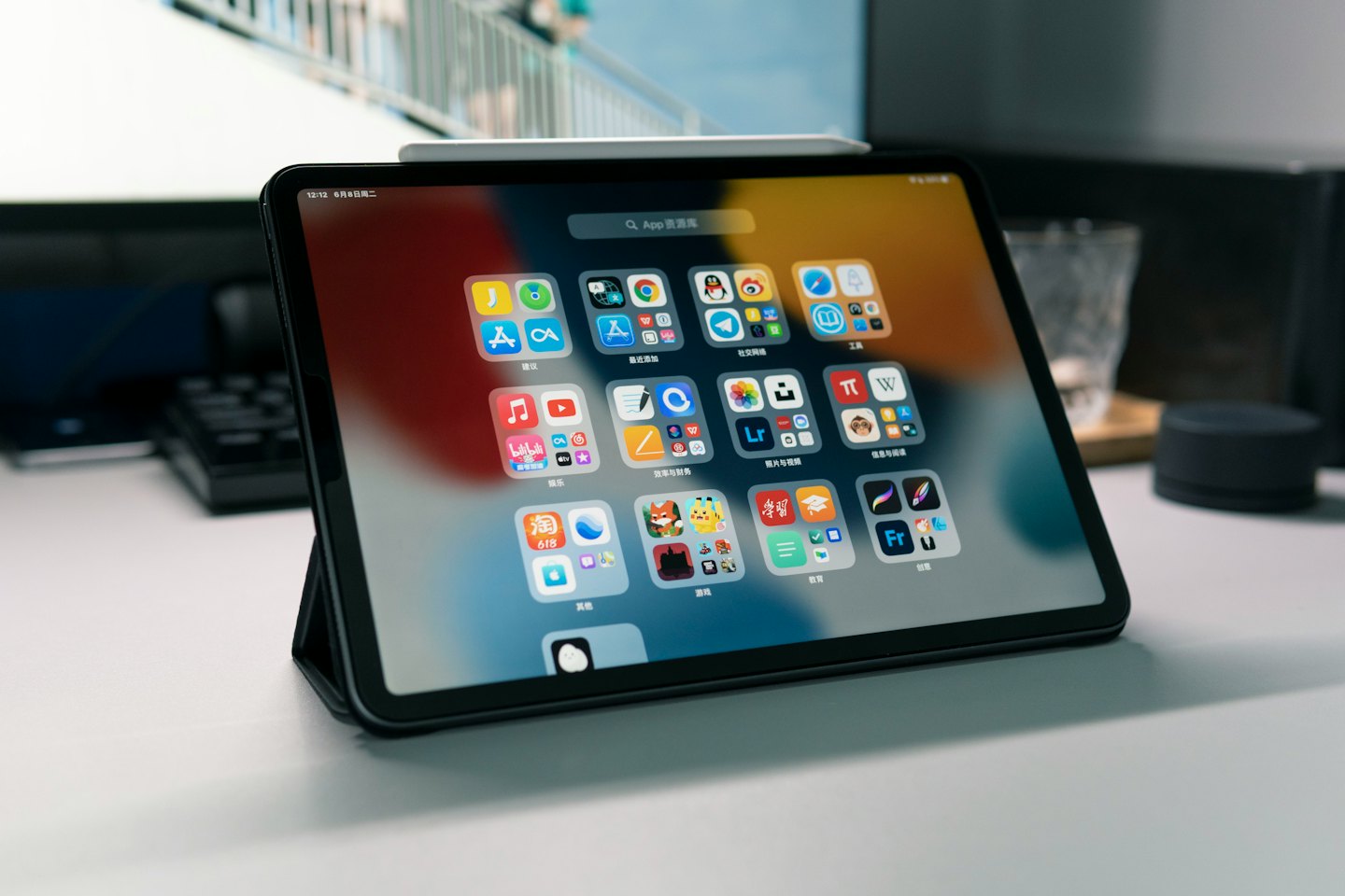 Tablet con icone di app colorate su una scrivania bianca.