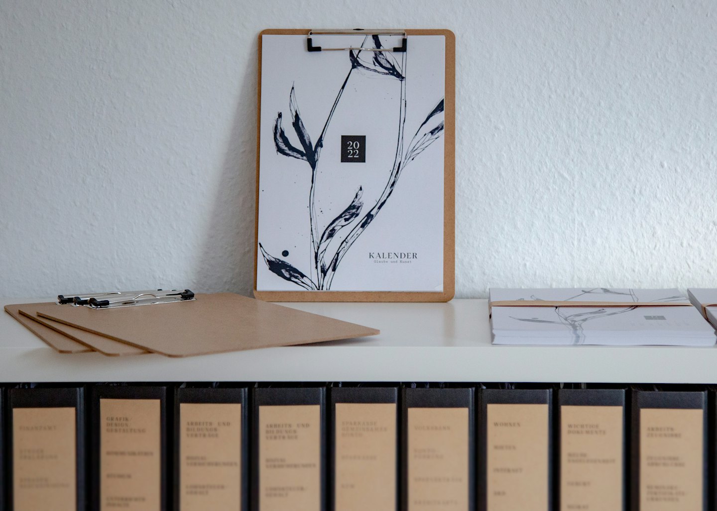 Appunti in legno con calendario 2022 su una mensola con forniture per ufficio.