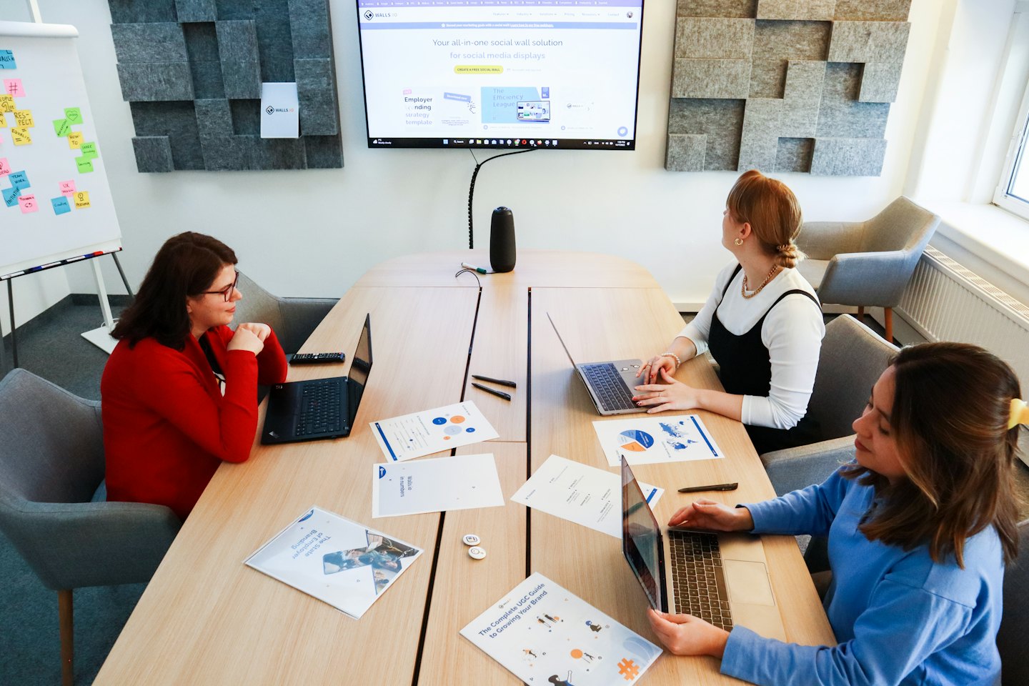 Tre donne lavorano insieme al computer portatile a un tavolo d'ufficio.